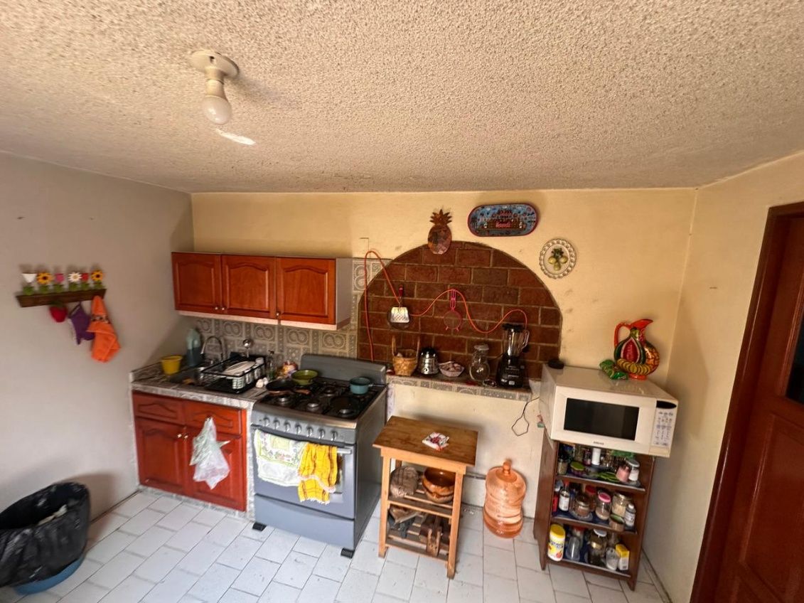 Cocina con arco de ladrillo aparente, estufa y alacena de madera