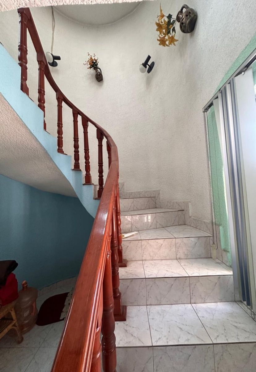 Escalera con escalones de mármol y barandal de madera torneada