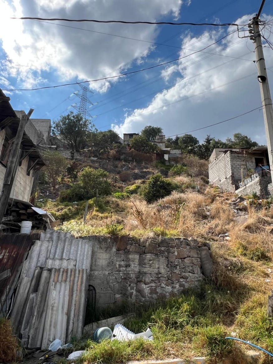 Superficie del terreno con muro de contención de piedra